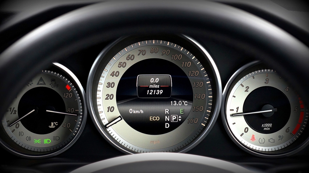 Close-up of a car dashboard showing the speedometer and rev counter.